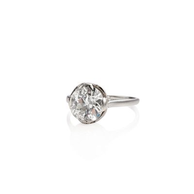 a close up of a diamond ring on a white surface