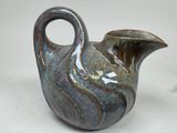 a blue and brown vase on a white surface
