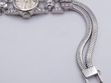 an image of a watch with a chain around it on a white surface