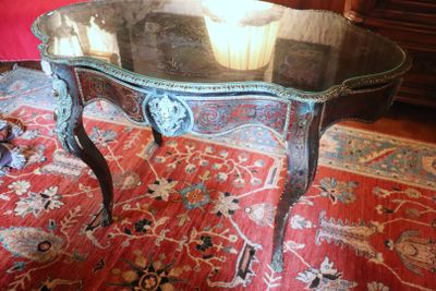 a table with a glass top on a red rug