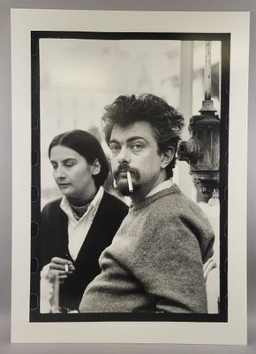 black and white photograph of a man smoking a cigarette next to a woman