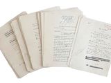 Plusieurs feuilles de papier sont empilées les unes sur les autres sur une surface blanche.