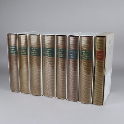 six books are lined up in a row on a white surface