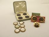 a box of buttons and a pair of earrings sitting on a table