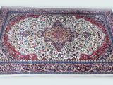 un grand tapis oriental posé sur une surface blanche