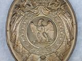 une image représentant une assiette en or sur laquelle figure un aigle