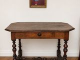 une petite table avec un plateau en bois et un tableau accroché au mur
