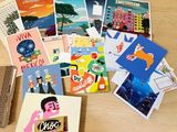 a lot of postcards on a table with a remote control