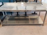 a stainless steel table with a marble top in a room