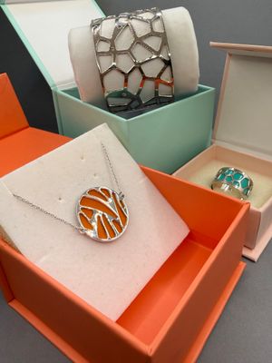 trois boîtes contenant des bijoux, posées sur une table