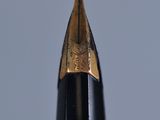a close up of a pen ' s tip with a blue sky in the background