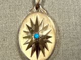 a silver and gold locke with a blue stone in it