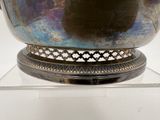 a large metal bowl on a glass stand