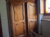 un lit en bois dans une chambre avec une fenêtre et un radiateur