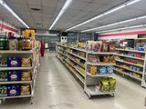 many shelves in the store with food and drinks on them
