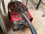 a red box with a black handle sitting on the floor
