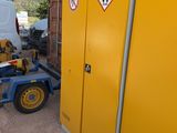 a yellow cabinet with a sign on it next to a white van