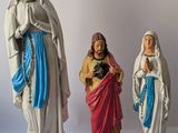 three figurines of jesus, mary, and jesus on a white background