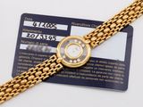 an image of a gold watch with a card attached to it