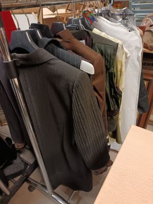 many clothes hanging on a rack in a clothing store