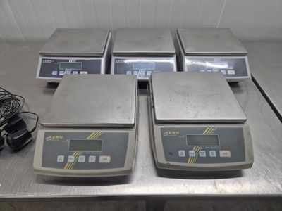 trois balances électroniques posées sur une table en métal