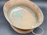 a brown bowl with a handle sitting on a black surface