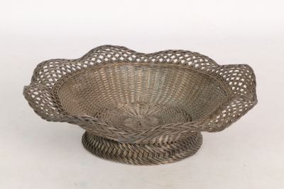 une image représentant un saladier en osier posé sur un support, sur fond blanc