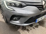 the front end of a silver car with a license plate on it