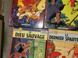 several books of comics are on a table in a room