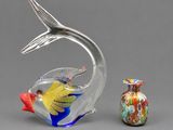 a glass figurine of a fish and a small vase