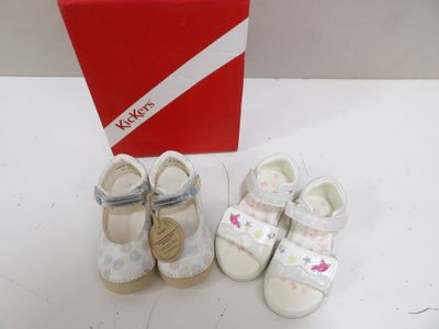 two pairs of baby shoes next to a red box