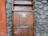 une grande armoire en bois avec des tiroirs, placée devant un mur en pierre