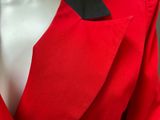 a close up of a red suit with a black tie on a mannequin mannequin