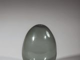 a green glass ball sitting on a white surface