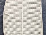 a close up of a white wicker purse on a black surface