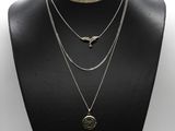 a black mannequin with three different necklaces on it
