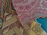 many different patterns and colors of fabric on a table