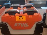 an orange and white stihl battery box sitting on top of a counter
