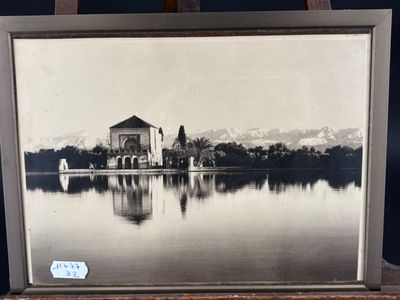 an old photo of a church on a lake with mountains in the background