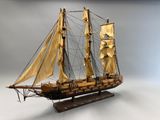 une photo d'une maquette de voilier posée sur un socle en bois