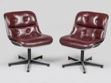 une paire de fauteuils de salon en cuir rouge montés sur roulettes, sur fond blanc