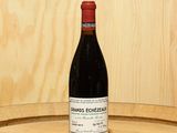 a bottle of wine sitting on top of a barrel