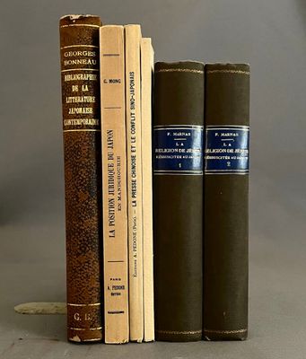 trois livres posés l'un à côté de l'autre sur une table