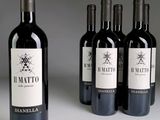 quatre bouteilles de vin rouge sont alignées sur une table