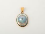 un pendentif en or orné d'une perle noire sur fond blanc