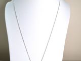 silver necklace with a yellow flower pendant on a white mannequin