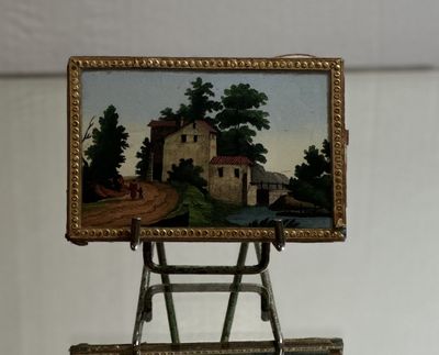 a miniature easel with a painting on it on a table