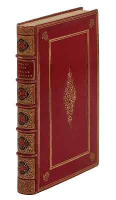 Le livre est rouge, avec des bordures dorées et un motif décoratif.