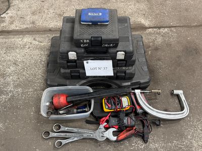 une trousse à outils posée par terre à côté d'une boîte à outils