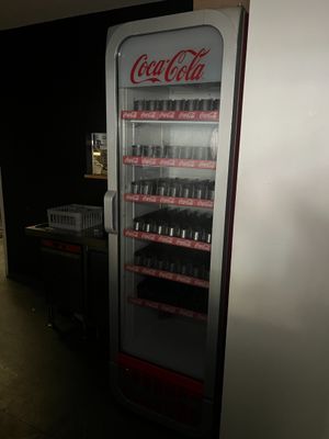 un distributeur de coca cola dans le coin d'une pièce